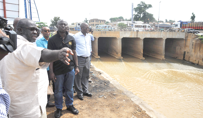 Mr Samuel Atta Akyea (2nd right) and some officials from his outfit looking at the drain at Avenor during the tour. Picture: EMMANUEL QUAYE